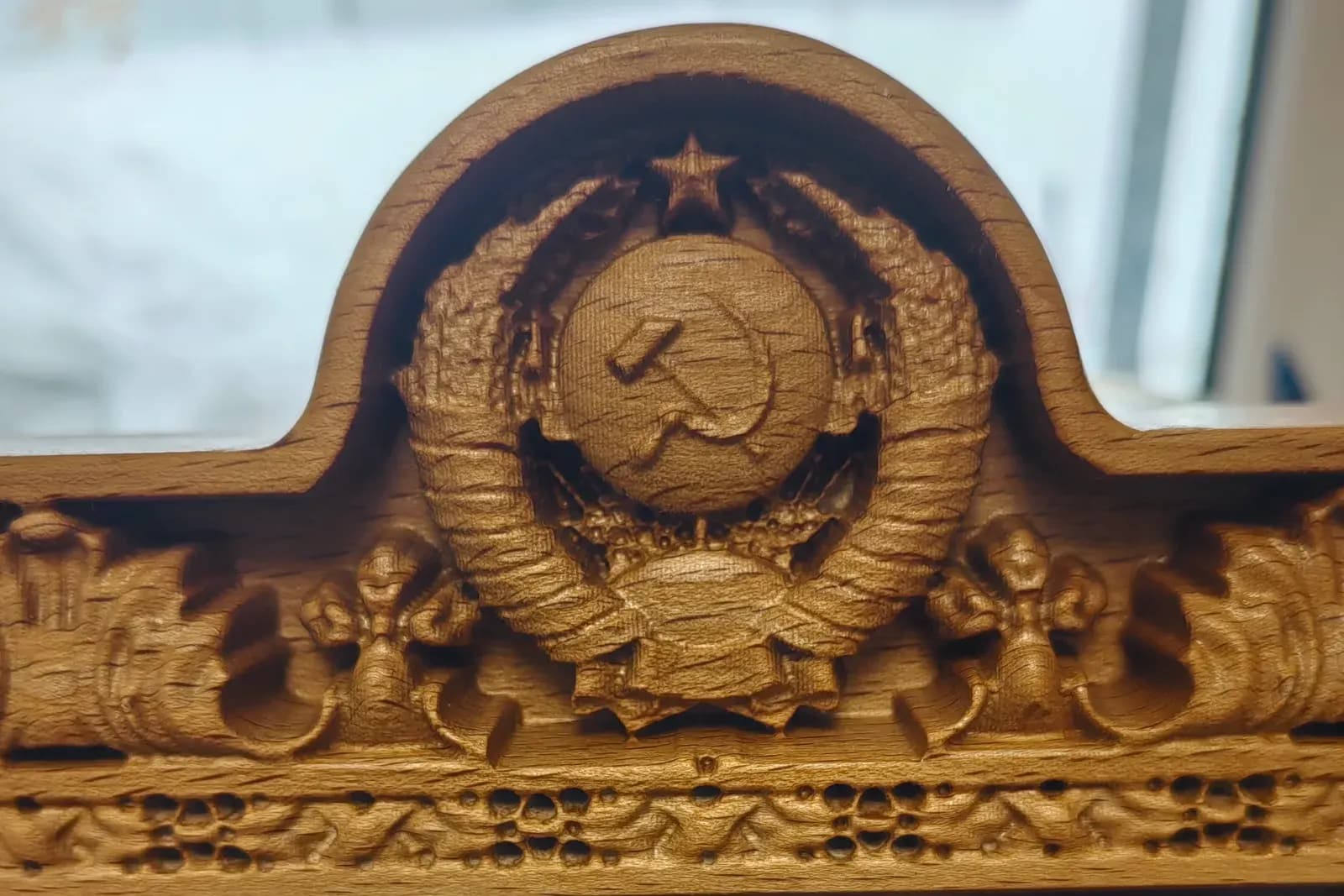 Многоуровневая резьба герба и орнамент багета вблизи