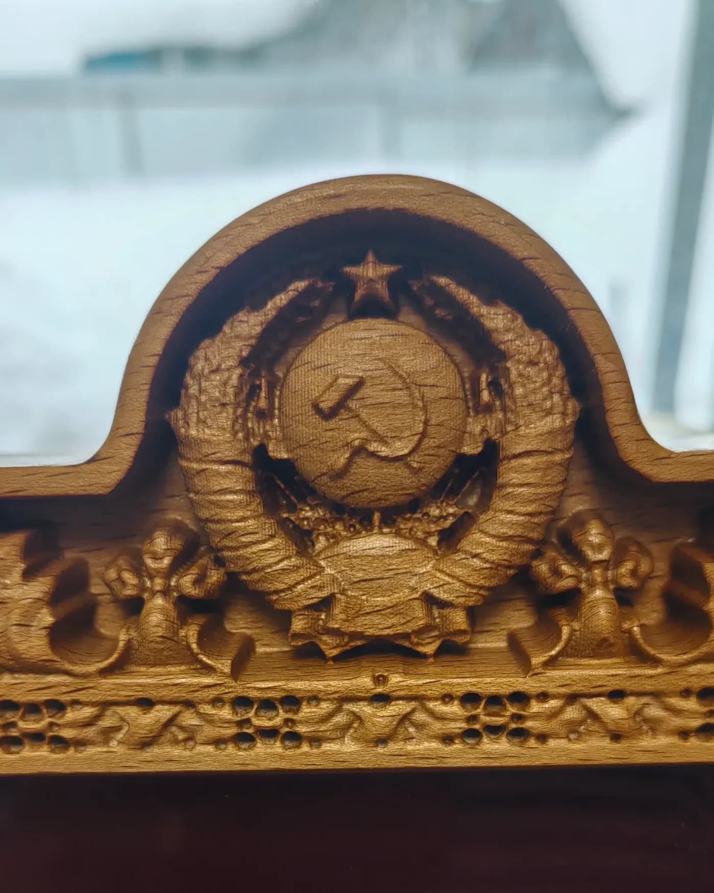 Резной герб в навершии наградной витрины из массива, крупный план